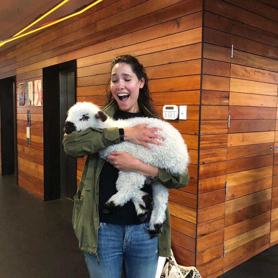 Joana smiling and holding a fluffy lamb